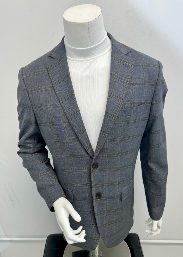 A mannequin is wearing a grey plaid jacket and a white turtleneck.