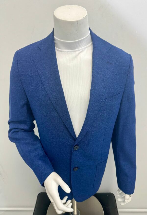 A mannequin wearing a blue jacket and a white turtleneck