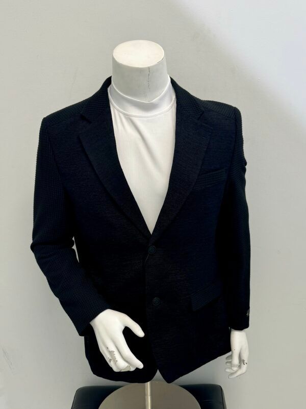 A mannequin wearing a black jacket and white turtleneck