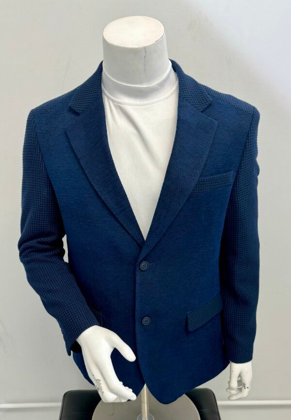A mannequin wearing a blue jacket and white turtleneck