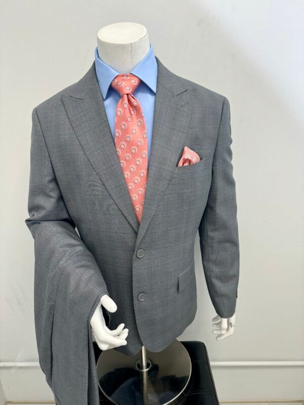 A mannequin is wearing a grey suit with a pink tie
