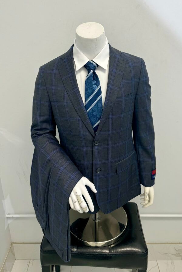 A mannequin wearing a suit and tie is sitting on a stool.