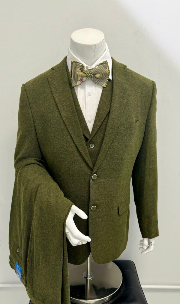 A mannequin is wearing a green suit and bow tie.
