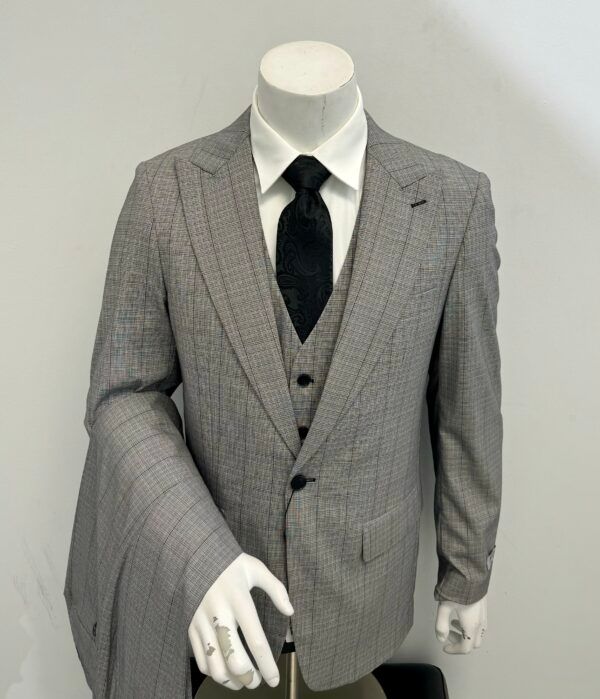 A man in a suit and tie is standing on a mannequin.