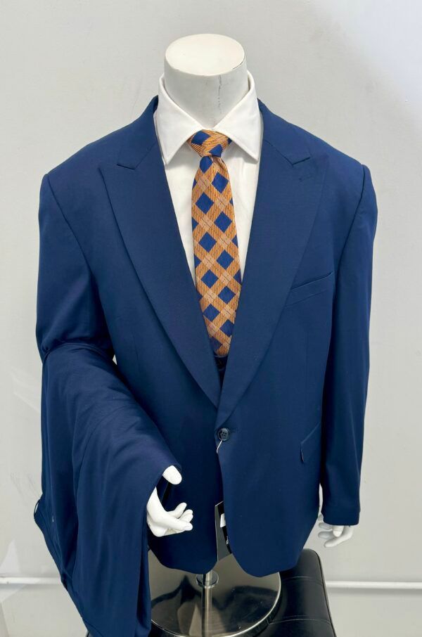 A blue suit with an orange tie is on a mannequin.