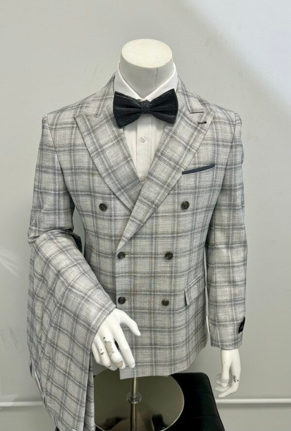 A mannequin is wearing a white plaid suit and bow tie.