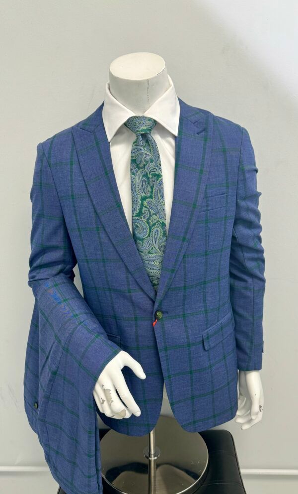 A blue suit with a green tie is on a mannequin.