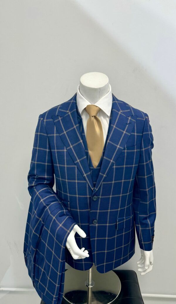 A blue suit with a gold tie is on a mannequin.