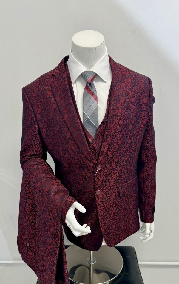 A mannequin is wearing a red suit and tie.