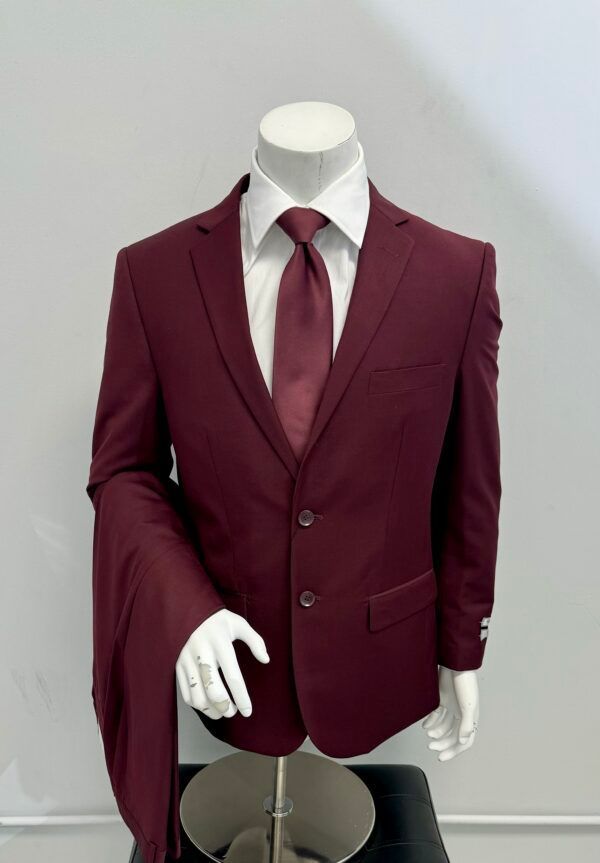 A mannequin is wearing a maroon suit and tie