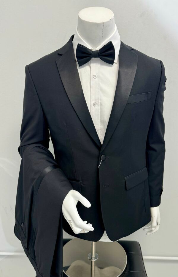 A black tuxedo with a bow tie is on a mannequin.