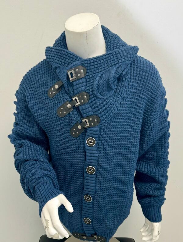 A mannequin wearing a blue sweater with buckle straps