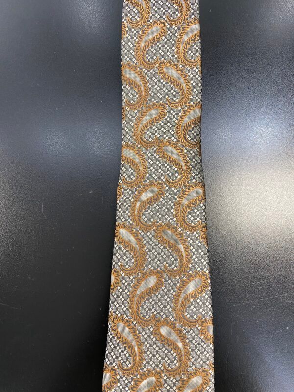 A close up of a paisley tie on a black surface