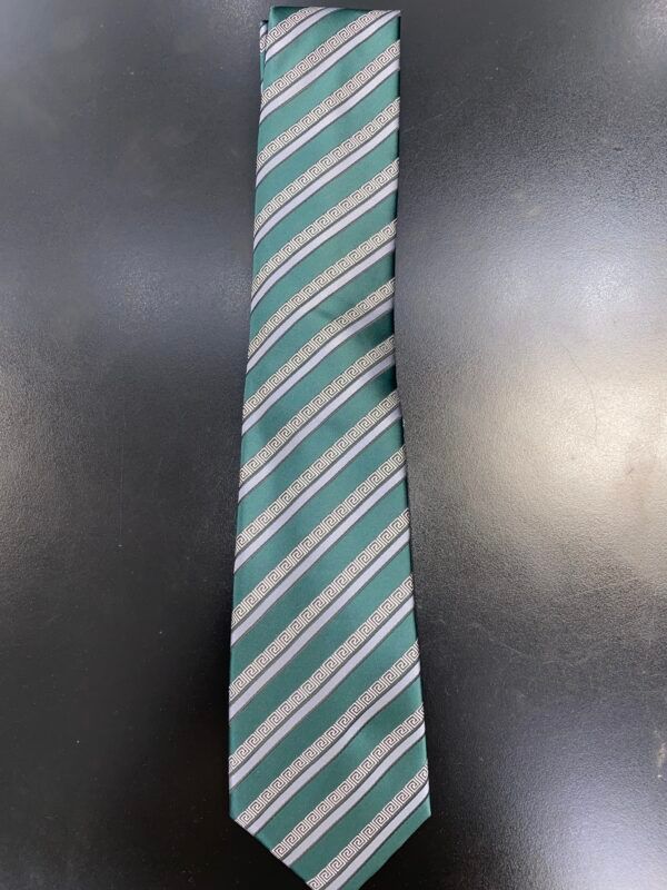 A green and white striped tie is sitting on a black table.