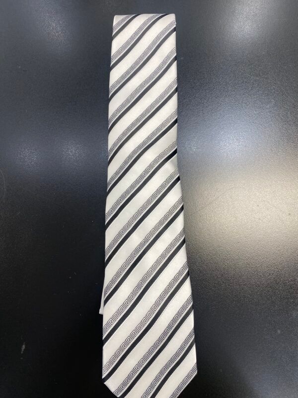 A black and white striped tie is sitting on a black surface.