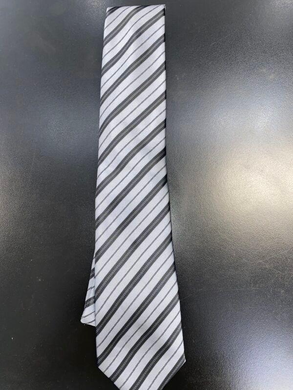 A black and white striped tie is sitting on a black table.