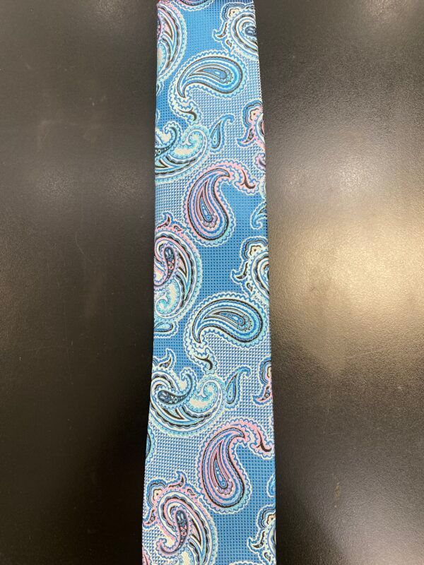 A blue paisley tie is sitting on a black table.