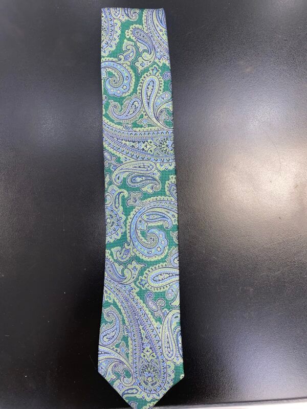 A green paisley tie is sitting on a black surface