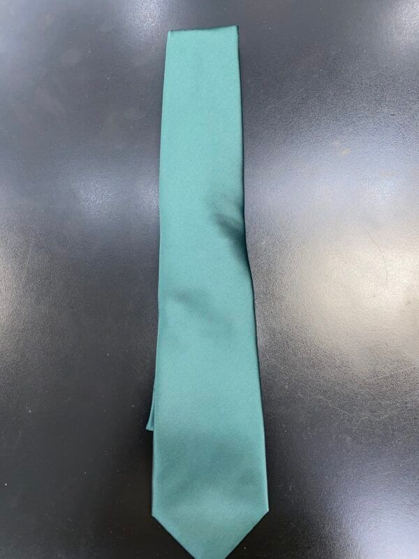 A green tie is sitting on a black table.