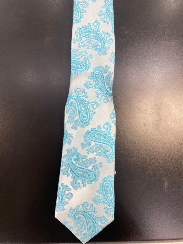 A white and blue paisley tie is sitting on a black surface.