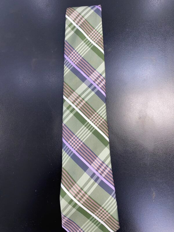 A green and purple plaid tie is sitting on a black table.