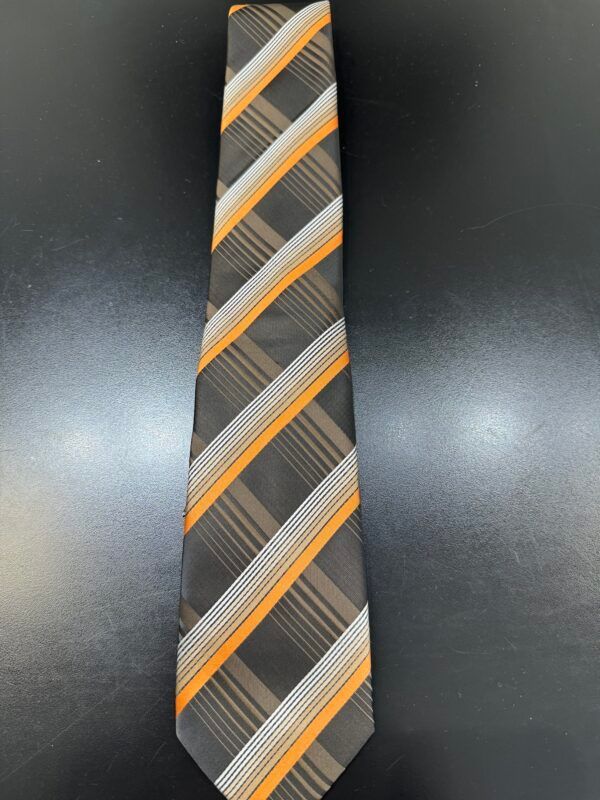 A black and orange striped tie is on a black surface