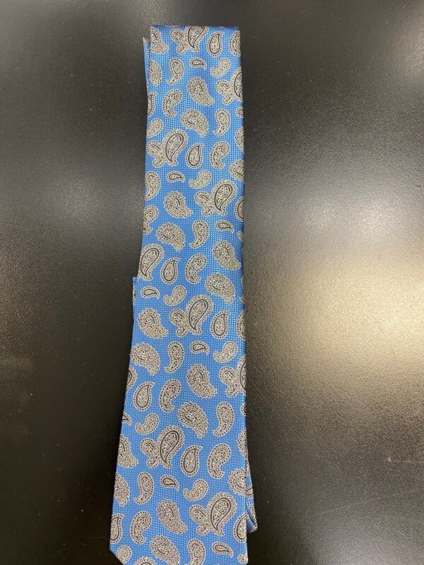 A blue paisley tie is on a black surface