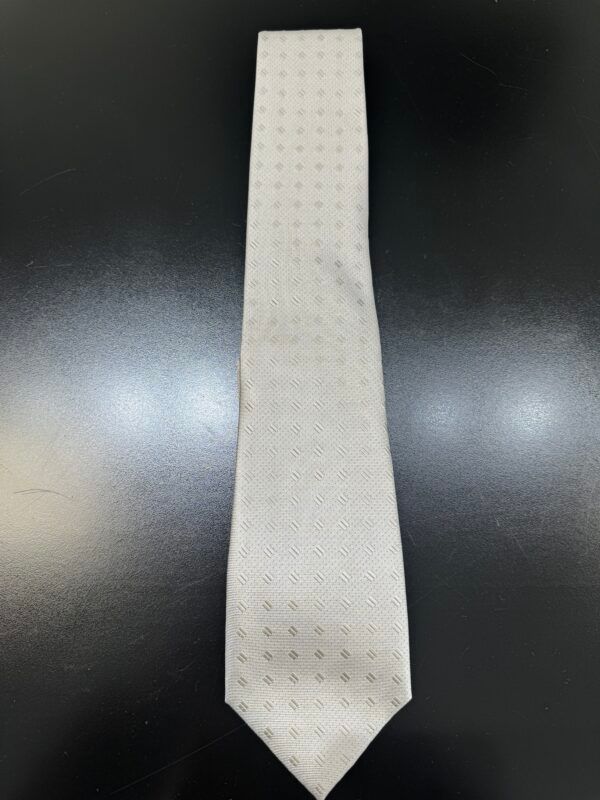 A white tie is sitting on top of a black table.