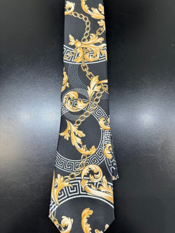 A black tie with gold chains and leaves on it