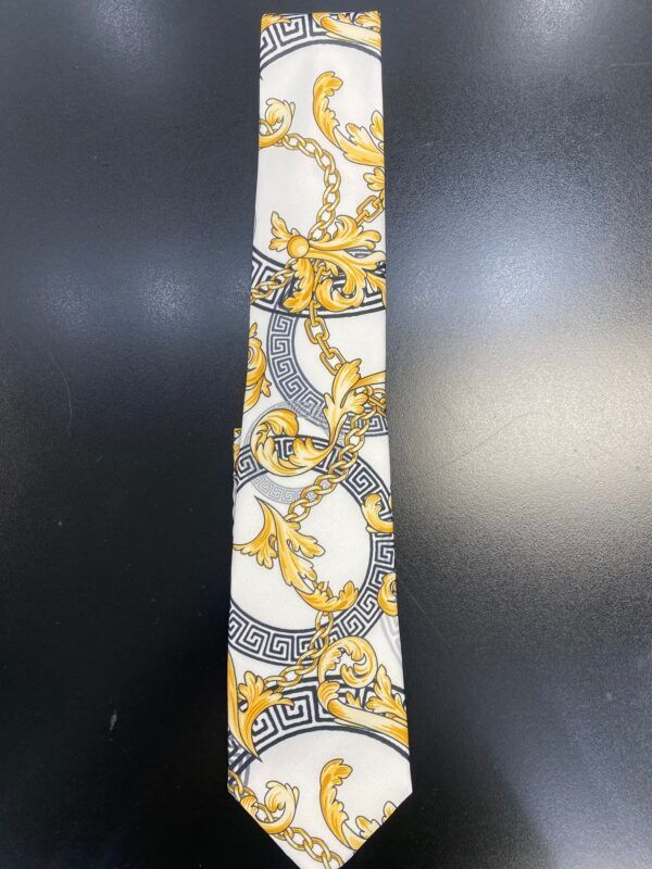 A white and gold tie with a greek key pattern