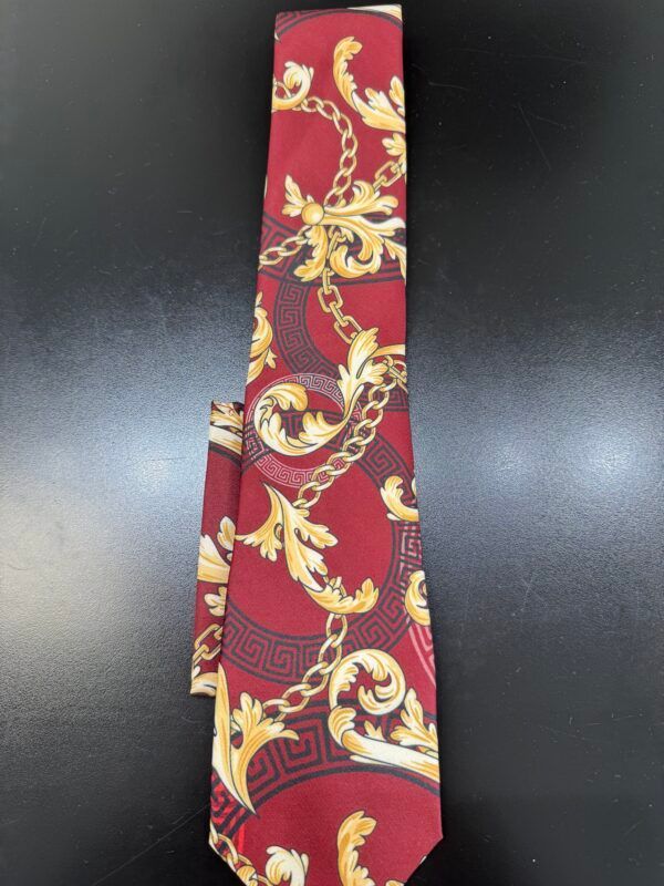 A red tie with gold chains and leaves on it