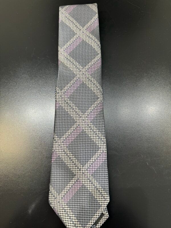 A gray and pink tie is sitting on a black table