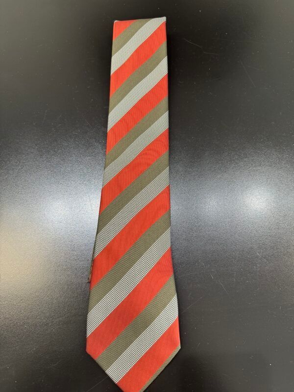 A red and grey striped tie is on a black surface