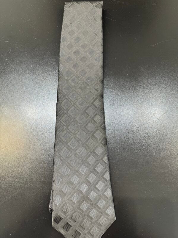A grey tie is sitting on a black table.