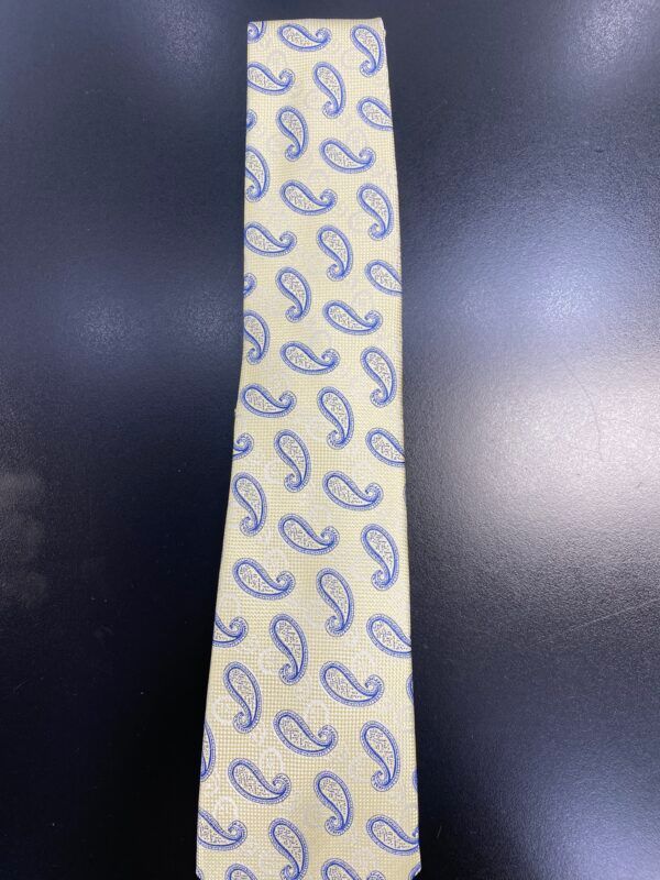 A tie with a paisley pattern on it is on a black surface.