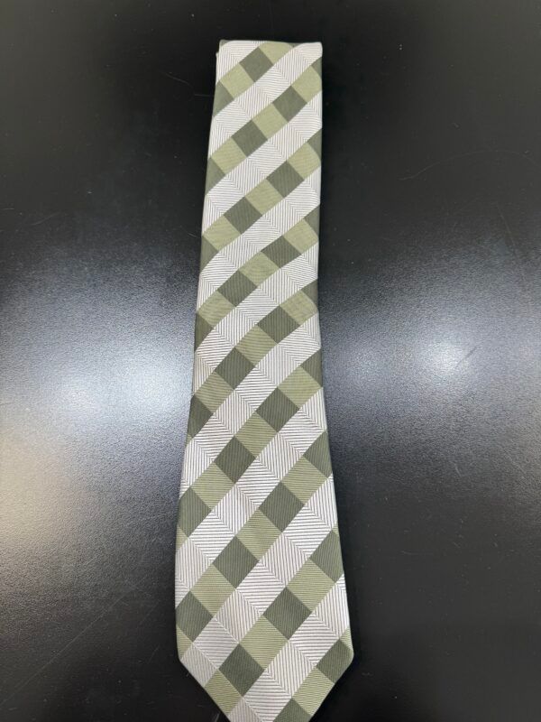 A green and white plaid tie is sitting on a black table.