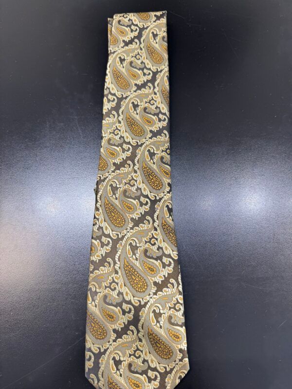 A tie with a paisley pattern is on a black surface