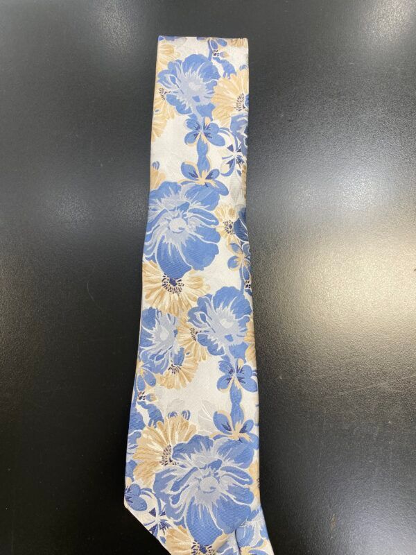 A white tie with blue and yellow flowers on it