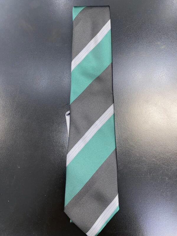 A green and gray striped tie is sitting on a black table.