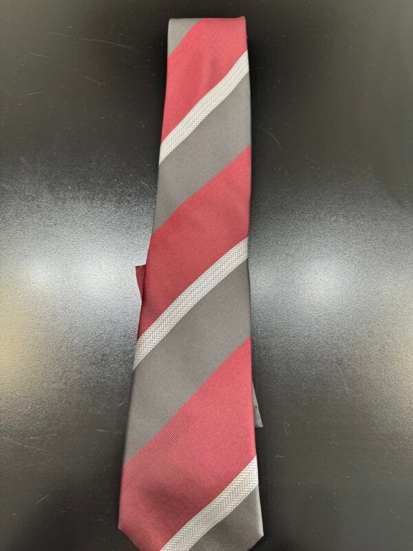 A red and grey striped tie is sitting on a black table