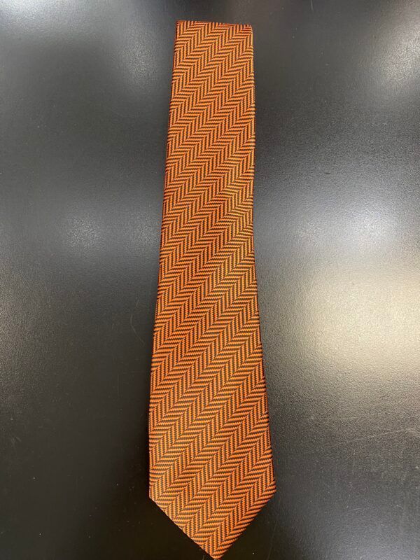 An orange tie with a herringbone pattern on it