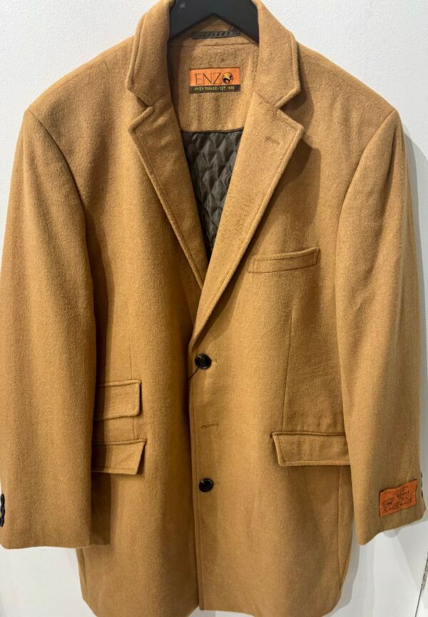 A tan coat is hanging on a black hanger
