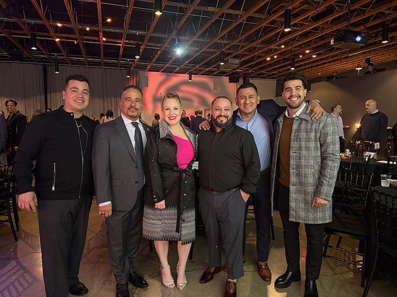 Group of people posing for a photo at an event in a large venue.