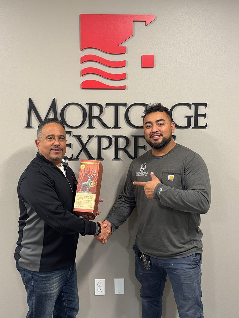 Two men shaking hands in front of a 