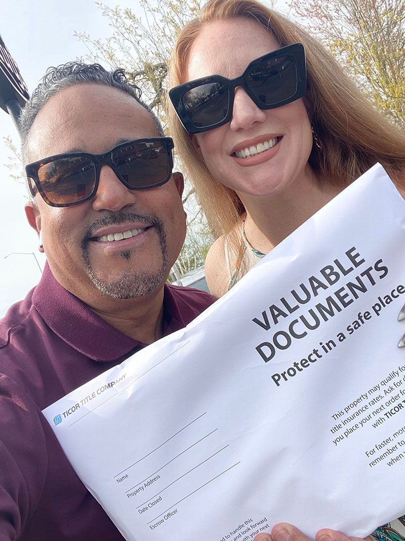 Couple holding a document envelope that reads 