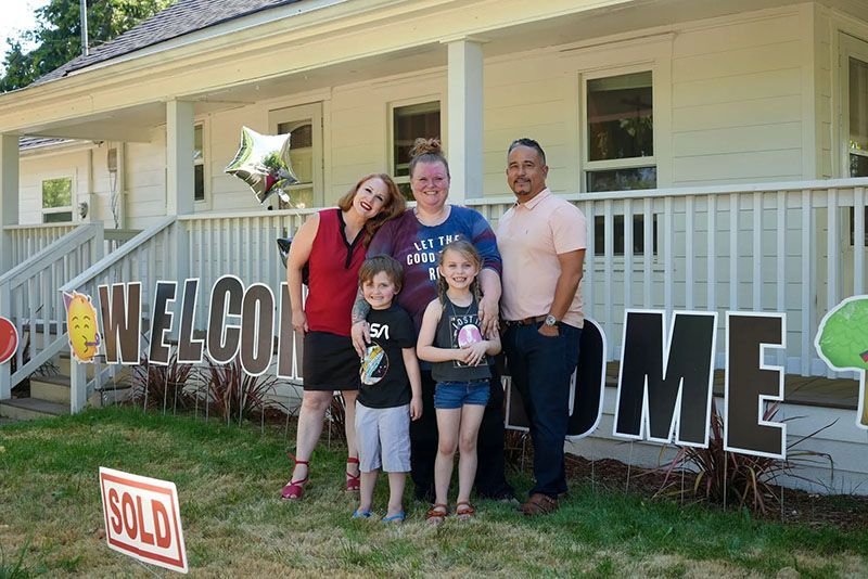 Family standing in front of their new house, a 