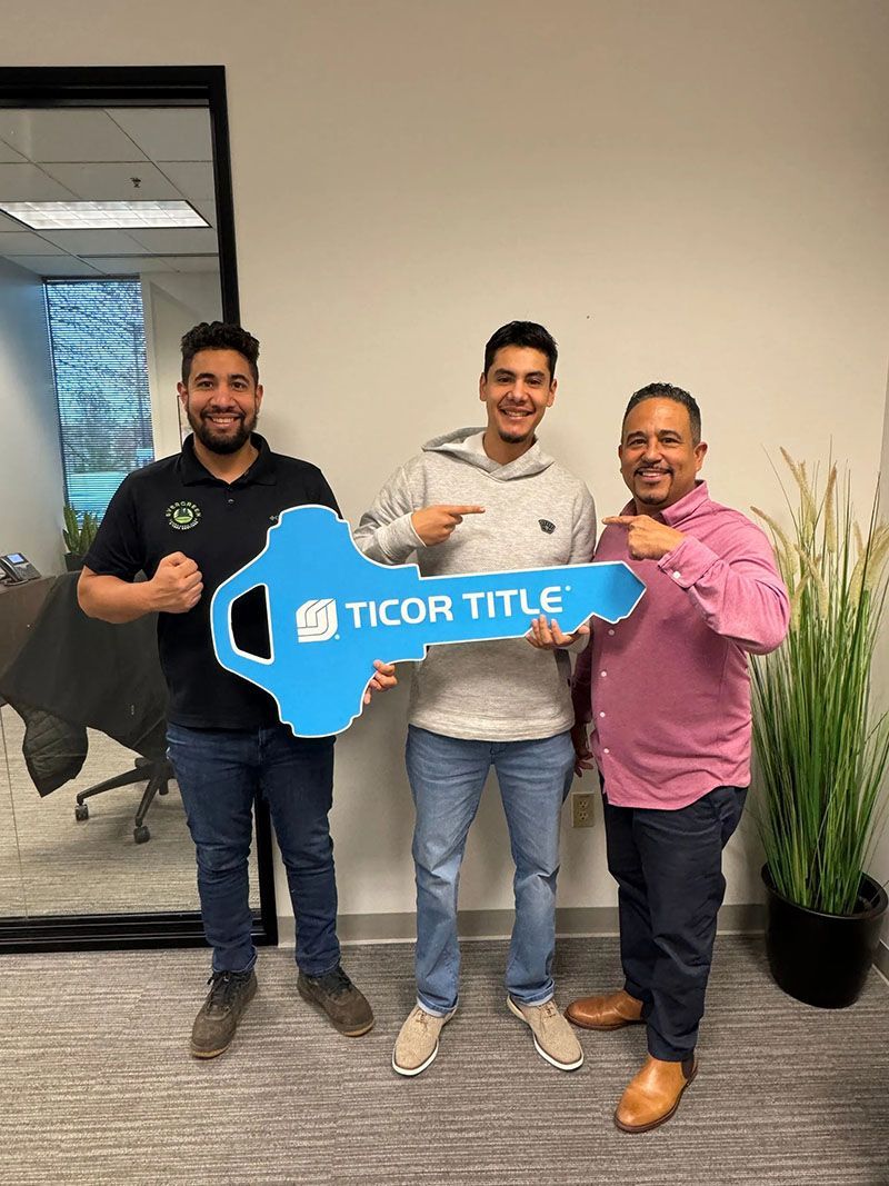 Three men holding a giant blue key with 