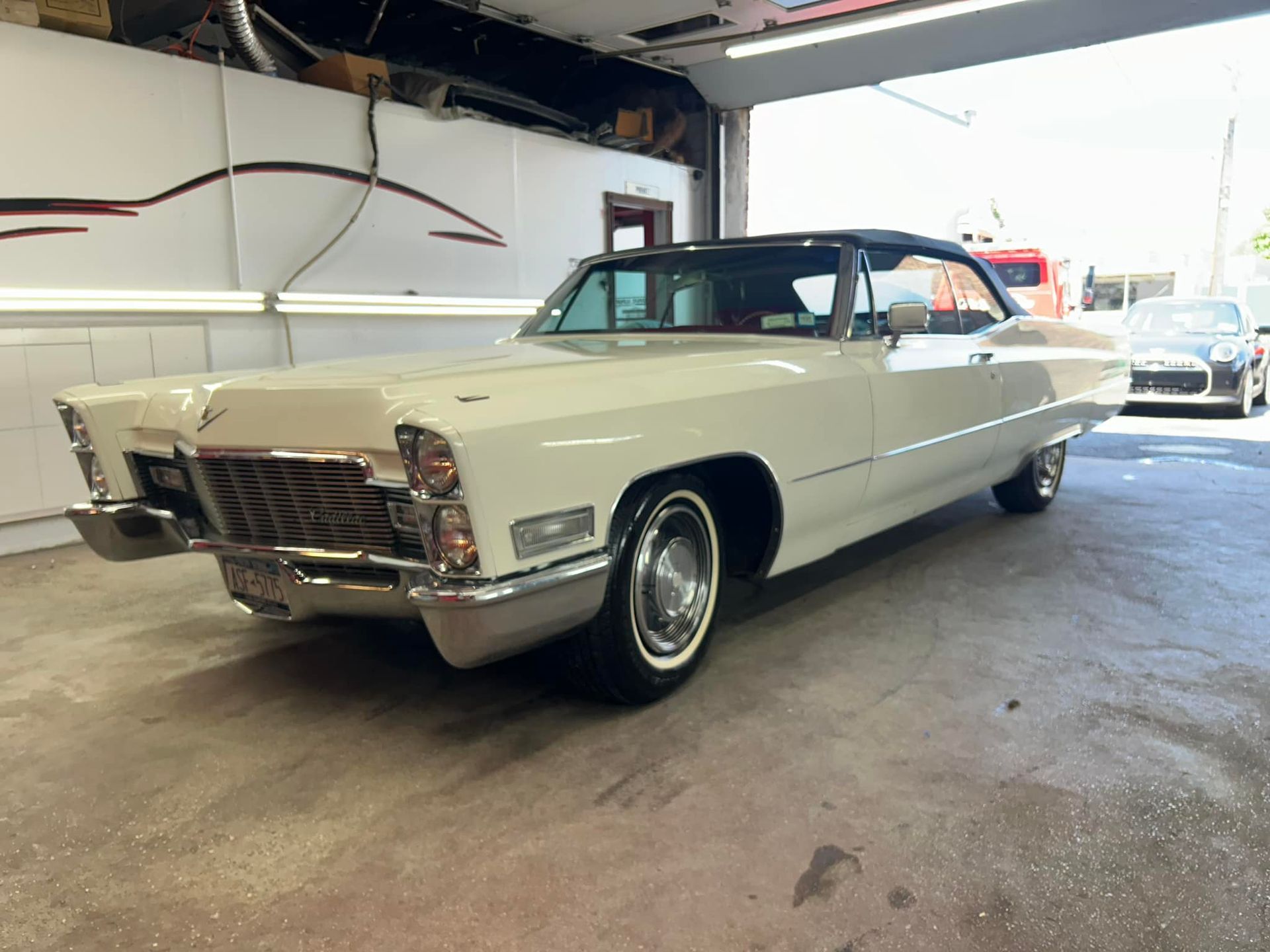 White vintage Cadillac Coupe parked in a garage.