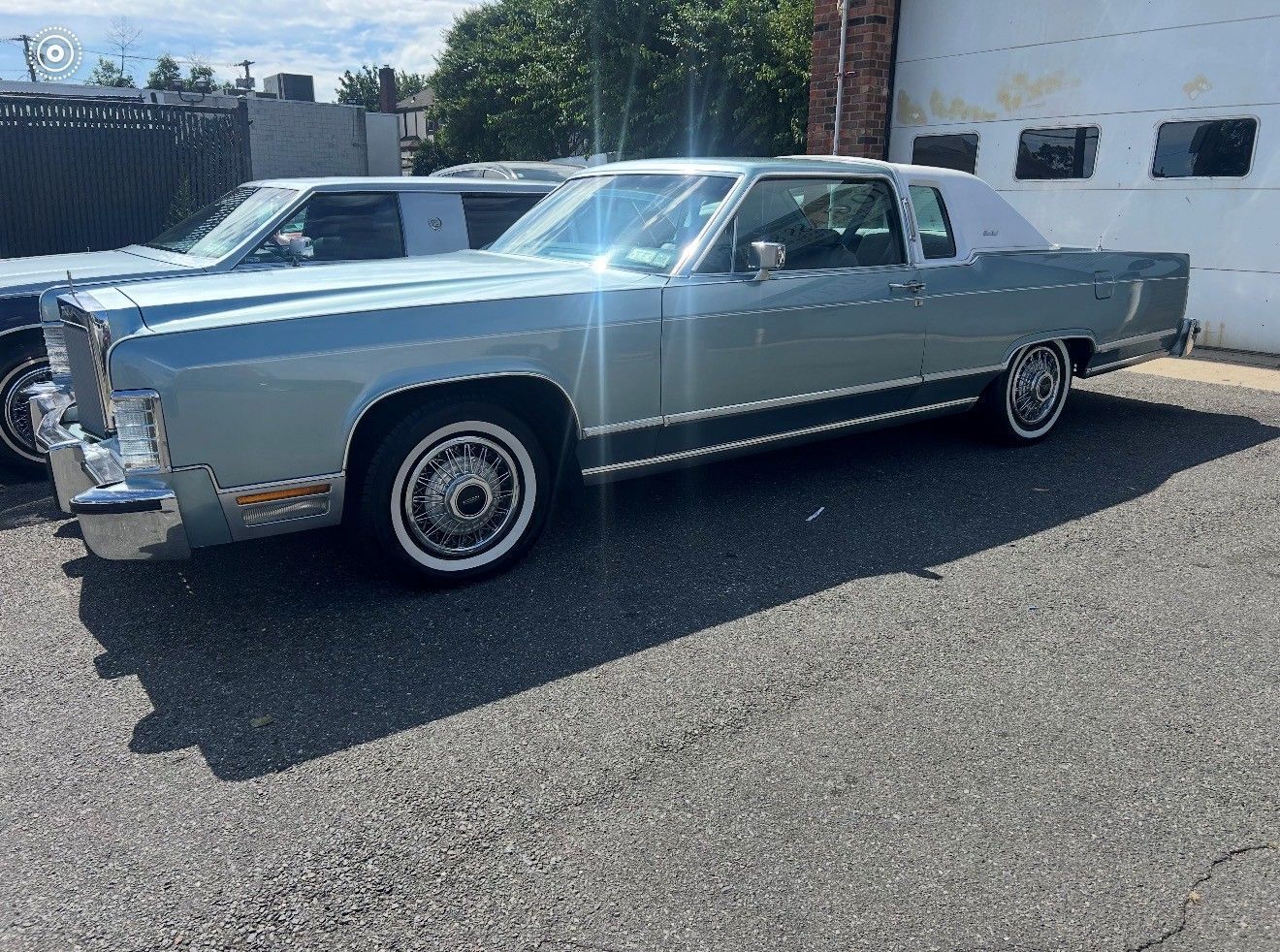 Light blue vintage Lincoln Continental coupe parked outside with a white roof.