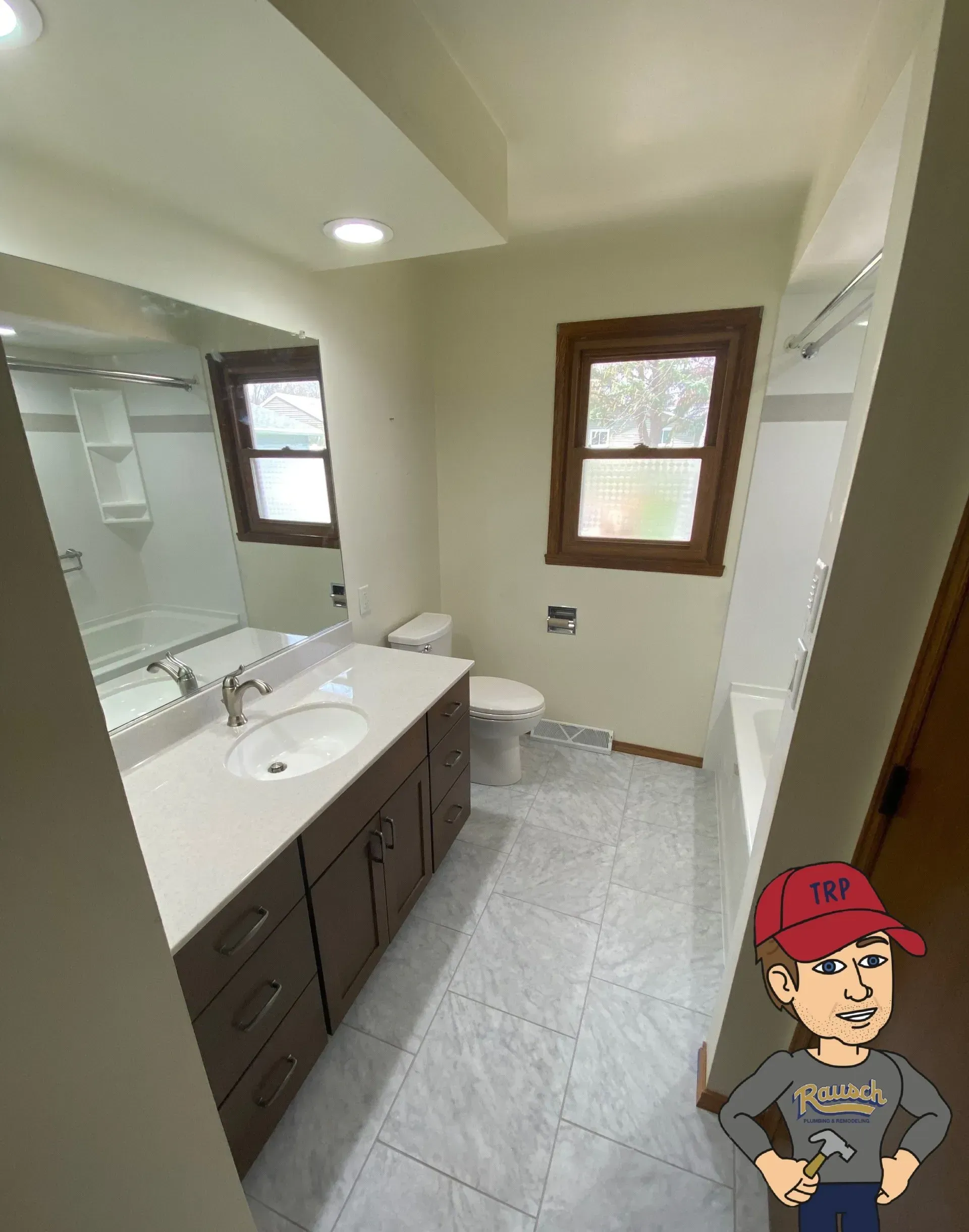 Bathroom renovation: Brown vanity, white sink, tiled floor, window, toilet, shower. Cartoon character in corner.